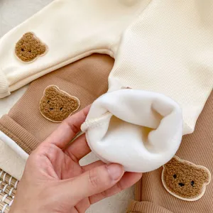 Detail of warm fleece lining and cute bear embroidery on knit infant thermal pants