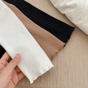 Close-up of ribbed knit cotton fabric texture showing softness in white, brown and black