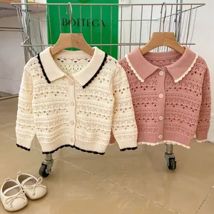Detail of hollow-out floral knit patterns on spring toddler cardigans in pink and cream