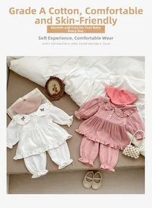 Détail d'un ensemble pyjama bébé en gaze de coton avec broderie cerise et volants