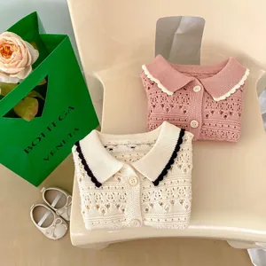 Close-up of baby girl hollow knit cardigan with Peter Pan collar and button details