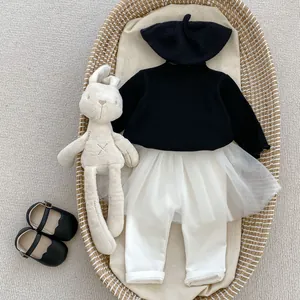 Flat lay of girl's black long sleeve top and white tulle skirted leggings in basket