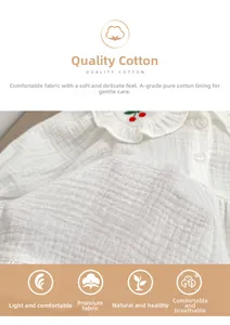 Détail du vêtement bébé avec broderie cerise sur col à volants et tissu en coton gaufré