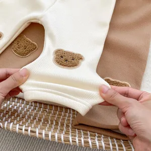 Elastic baby ribbed leggings with cute teddy bear patches in cream and brown colors