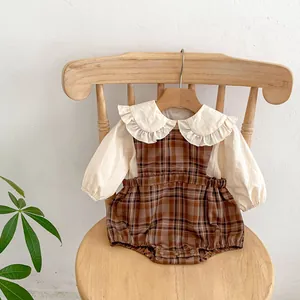 Détail de l'ensemble bébé vintage avec chemise à col volanté et barboteuse à carreaux