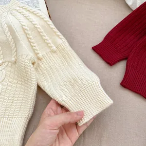 Detailed view of cable knit pattern and ribbed cuffs on a baby knitted sweater