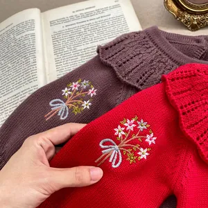 Detail of baby knit romper with ruffled collar and exquisite floral embroidery design