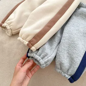 Detail view of thick fleece-lined joggers with side stripes and elastic ankle cuffs