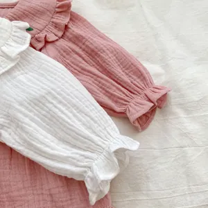 Détail des hauts en gaze de coton pour bébé avec cols volantés et broderies cerises