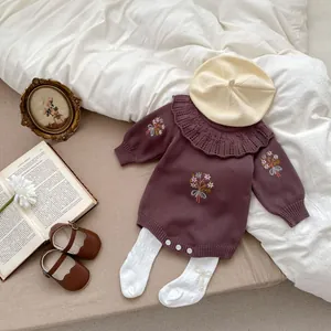 Flat lay of baby girl knit romper with floral embroidery and ruffle collar details