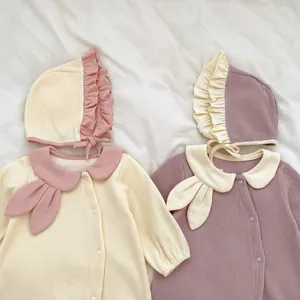 Detail of baby bunny ear collar rompers with matching ruffled hats in pink and beige