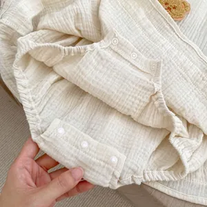 Nahaufnahme der Baby-Body-Druckknöpfe und der weichen, zwelagigen Mullstruktur