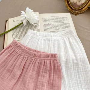 Détail de shorts bébé en gaze de coton respirant avec taille élastique rose et blanc