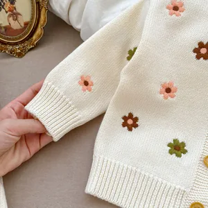 Détail du cardigan en tricot pour bébé avec broderie florale et bords côtelés