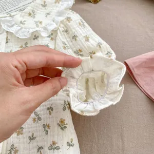 Detail of baby floral shirt featuring white lace collar and elastic ruffled sleeve cuffs