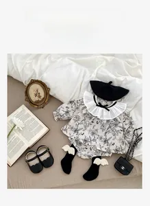 Flat lay of baby girl floral romper set with frill collar and Mary Jane shoes in Class A cotton