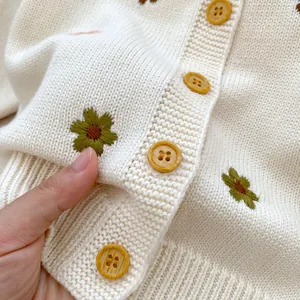 Gilet en tricot ivoire pour bébé avec broderie florale et boutons en bois de près
