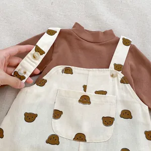Detail von Baby-Latzhose mit Bärenmuster und langärmeligem Set mit verstellbaren Trägern