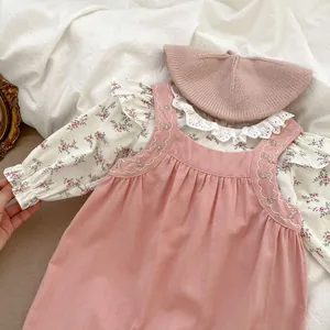 Dettaglio completo di blusa a fiori, scamiciato in velluto rosa e basco per neonata