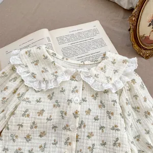 Detail of baby girl floral shirt with lace collar and soft cotton gauze texture