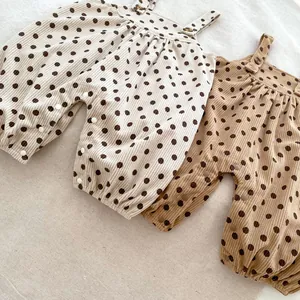 Detailed view of polka dot corduroy baby jumpsuits with adjustable shoulder straps