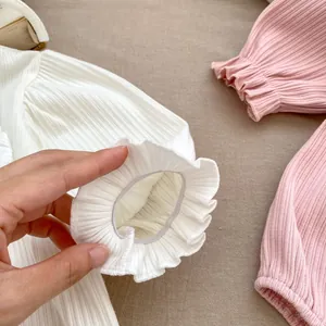 Detail der gerafften elastischen Bündchen am gerippten Baby-Body in Rosa und Weiß