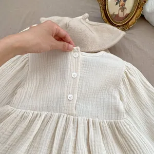 Detailansicht beige Babykleid aus Baumwollmull mit Rückenknöpfen und plissierter Textur