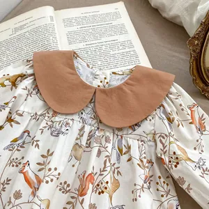 Close-up of baby bodysuit with vintage animal print and large brown Peter Pan collar