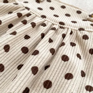 Infant beige corduroy polka dot jumpsuit with fine waist pleats and soft texture