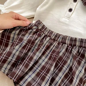 Kleinkind Mädchen-Set mit cremefarbenem Poloshirt und kariertem Faltenrock mit Dehnbund