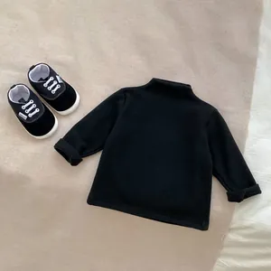 Flat lay of black mock neck long sleeve baby shirt and matching Angel graphic shoes