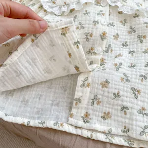 Close-up of floral baby romper featuring breathable double cotton gauze and lace collar