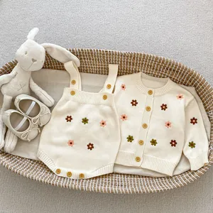 Ensemble cardigan et barboteuse en tricot avec broderies de fleurs dans un panier