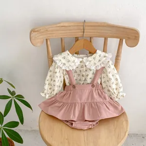 Detail of baby floral blouse with lace collar and dusty pink suspender dress set