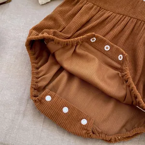 Close-up of caramel corduroy baby romper bottom with three white snap buttons