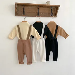 Detail view of baby ribbed overalls and long sleeve shirts in three neutral color palettes