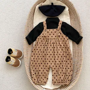 Flat lay of baby corduroy polka dot overalls with turtleneck top and knit beret