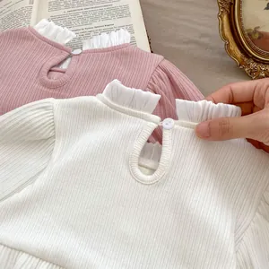 Detailansicht von Baby-Body mit Rüschenkragen, geripptem Baumwollstoff und Rückknopf