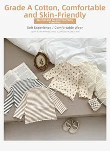 Detail of baby cotton long-sleeve shirts showing ruffles and diverse fabric patterns
