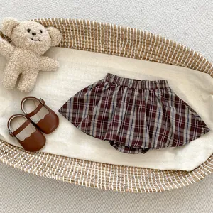 Detailansicht eines braun karierten Faltenrocks für Babys mit elastischem Bund und weichem Stoff