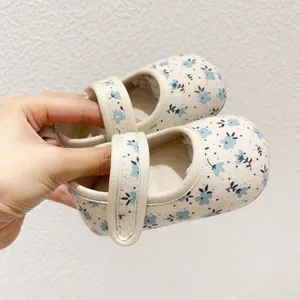 Gros plan de chaussures Mary Jane en toile pour bébé avec motif floral et bande velcro