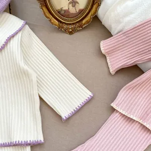 Detailaufnahme der Mädchen-Strickjacke mit feinen gewellten Häkelspitzen an den Säumen