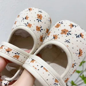 Gros plan du motif floral et du tissu en toile souple sur les chaussures Mary Jane pour bébé