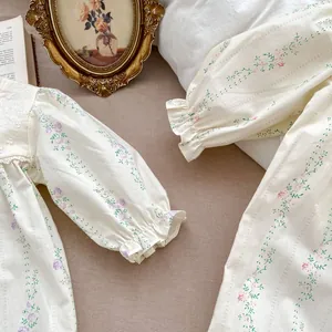 Detailed view of floral baby romper with lace collar and elastic ruffled cuffs