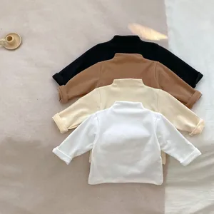 Kids turtleneck cotton undershirt in white, beige, brown and black stacked on soft fabric
