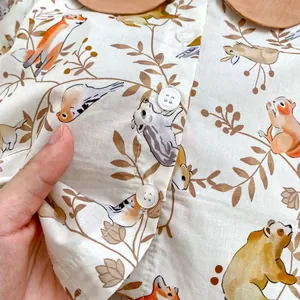Close-up of baby romper with cute forest animals print and Peter Pan collar