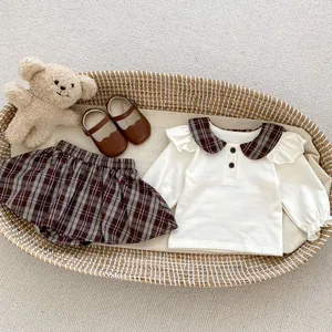 Mädchen-Set mit Karo-Peter-Pan-Kragen-Oberteil und Faltenrock im geflochtenen Korb