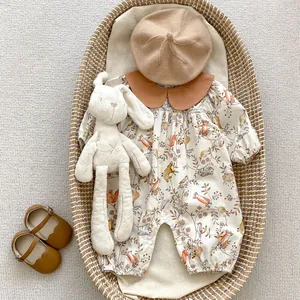 Detail of infant long sleeve jumpsuit with forest animal prints, beret and leather shoes