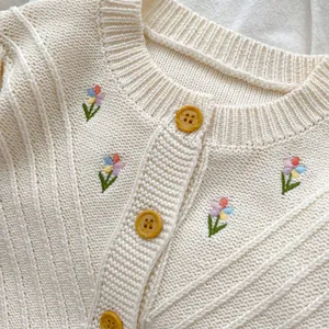 Cremefarbene Strickjacke für Mädchen mit bunten Blumenstickereien und Holzknöpfen