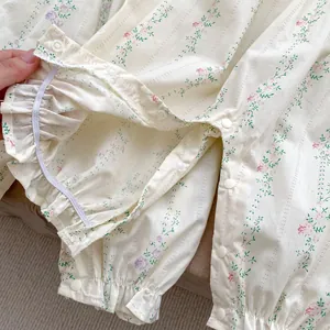 Macro detail of baby romper with floral print featuring ruffle cuffs and snap buttons